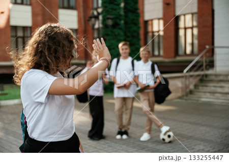 Standing and posing. Kids are near the school together, pupils 133255447