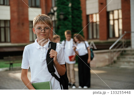 Standing and posing. Kids are near the school together, pupils 133255448