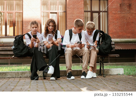 Kids are near the school together, pupils Kids are near the school together, pupils 133255544