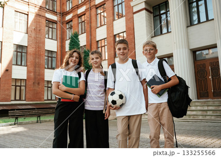 Group of kids are near the school together, pupils Group of kids are near the school together, pupils 133255566