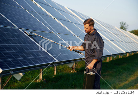 Man is working with solar panels outdoors at daytime 133258134