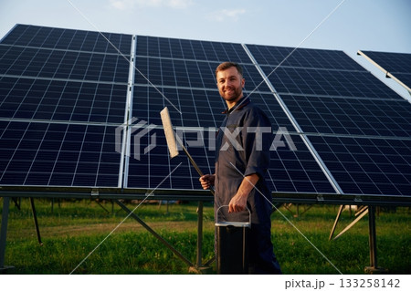 Keep it clean. Man is working with solar panels outdoors at daytime 133258142