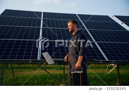 Keep it clean. Man is working with solar panels outdoors at daytime 133258143