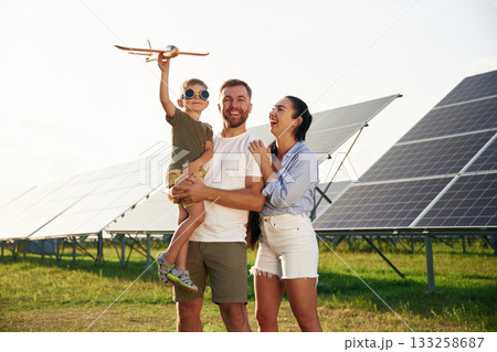 Family is together. Father, mother and little son are outdoors near solar panels 133258687