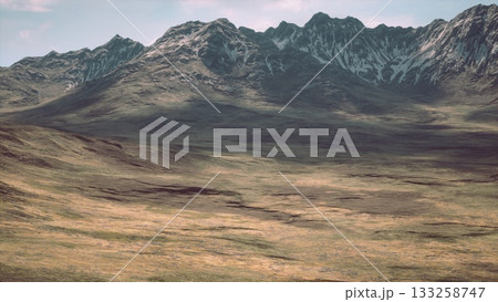 Vast open landscape features towering mountains and a serene valley under a clear sky. The natural beauty and rugged terrain invite exploration and admiration from nature lovers. Vast open landscape features towering mountains and a serene valley under a clear sky. The natural beauty and rugged terrain invite exploration and admiration from nature lovers. 133258747