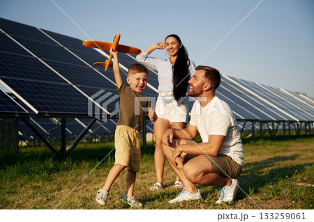 Imagination conception, with toy plane. Father, mother and little son are outdoors near solar panels 133259061