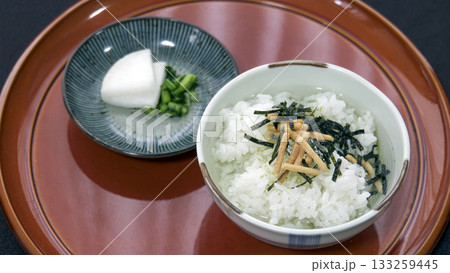 茶色い丸盆に乗せられた茶碗に入った海苔茶漬けと小皿の漬物 茶色い丸盆に乗せられた茶碗に入った海苔茶漬けと小皿の漬物 133259445