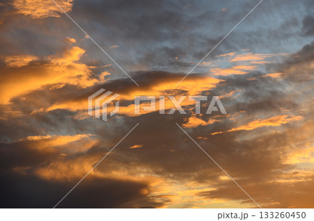 Golden hues dance across the evening sky as darkness begins to fall 133260450