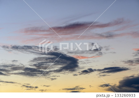 Vibrant clouds paint the sky with hues of blue, pink, and orange at dusk over a tranquil horizon Vibrant clouds paint the sky with hues of blue, pink, and orange at dusk over a tranquil horizon 133260933