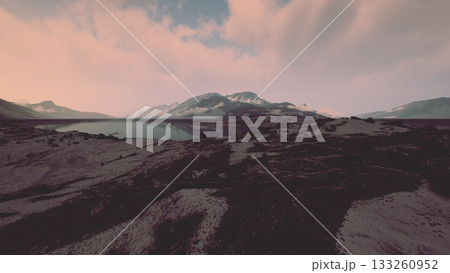 A tranquil landscape unfolds as the sun rises, illuminating a breathtaking view of mountains and a shimmering lake. The peaceful scene invites contemplation and appreciation of natures splendor. 133260952