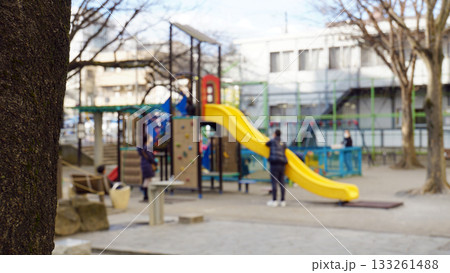 黄色い滑り台で遊ぶ子どもを両親が見守る公園のイメージ写真 黄色い滑り台で遊ぶ子どもを両親が見守る公園のイメージ写真 133261488