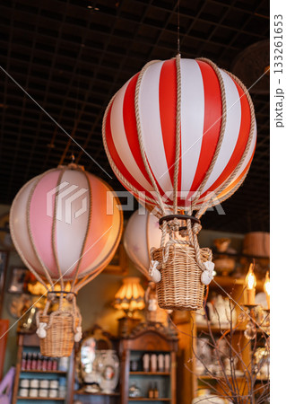 Decorative hot air balloons in a beautifully arranged interior. Soft lights, warm colors and elegant ornaments create a charming festive space with a travel-inspired theme 133261653