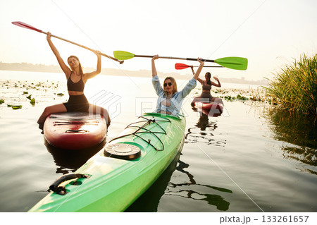 Finished, celebrating, hands up. Women friends are on sup board on the lake together Finished, celebrating, hands up. Women friends are on sup board on the lake together 133261657
