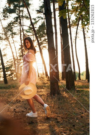 Amazing sunlight. Pretty young woman in pink dress is in the forest Amazing sunlight. Pretty young woman in pink dress is in the forest 133262815