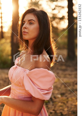 In pink dress. Pretty young woman is in the forest In pink dress. Pretty young woman is in the forest 133262832