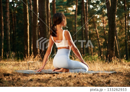 Peace and quiet, sitting. Woman is doing yoga fitness exercises in the forest Peace and quiet, sitting. Woman is doing yoga fitness exercises in the forest 133262933