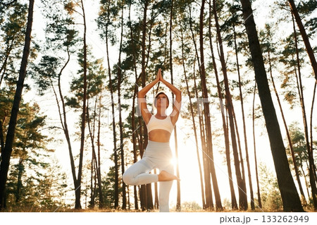 Stretching up, warm up exercises. Woman is doing yoga fitness exercises in the forest Stretching up, warm up exercises. Woman is doing yoga fitness exercises in the forest 133262949