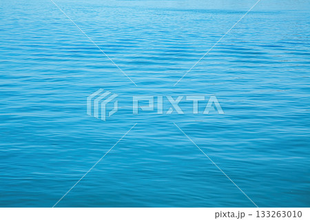 Calm river surface with gentle ripples reflecting blue sky on a sunny day Calm river surface with gentle ripples reflecting blue sky on a sunny day 133263010