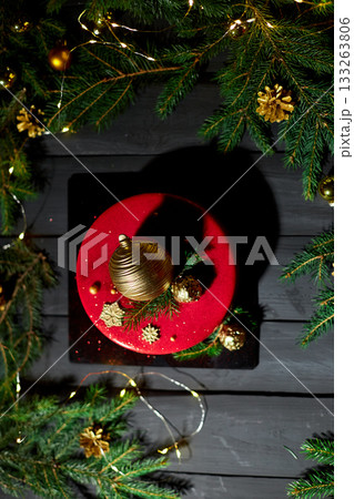Festive Red Cake Adorned With Golden Decorations and Greenery, Set Against a Backdrop of Sparkling Lights During a Holiday Celebration Festive Red Cake Adorned With Golden Decorations and Greenery, Set Against a Backdrop of Sparkling Lights During a Holiday Celebration 133263806