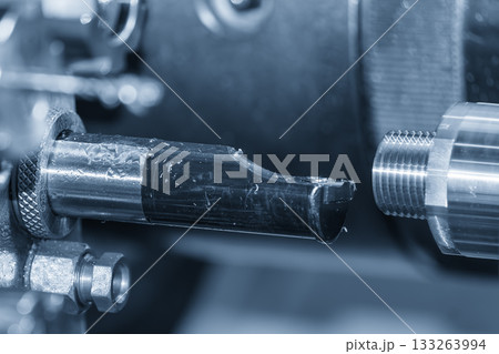 Close up scene multi-tasking CNC lathe machine swiss type tapping process the metal coupling parts in the light blue scene. Close up scene multi-tasking CNC lathe machine swiss type tapping process the metal coupling parts in the light blue scene. 133263994