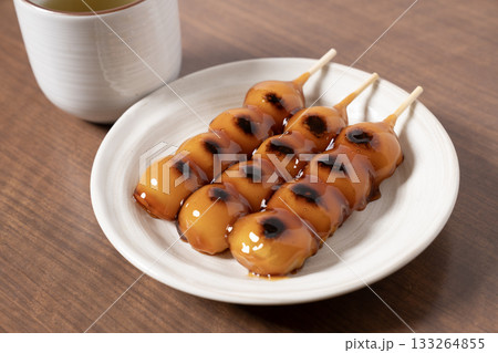 白い皿にのったみたらし団子とお茶 133264855