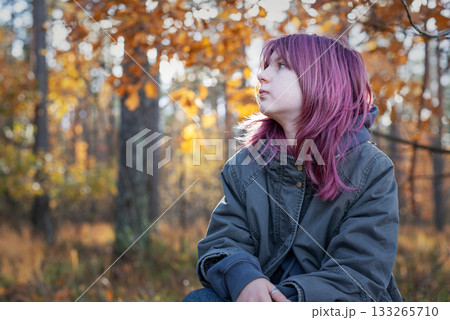 Teen girl with purple hair contemplating in autumn forest 133265710