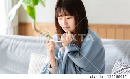 熱を測る体調不良の女性 133266415