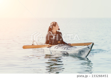 Kayaking Woman Water Sports - Woman in a kayak on the water, enjoying a peaceful morning paddle. Kayaking Woman Water Sports - Woman in a kayak on the water, enjoying a peaceful morning paddle. 133266451
