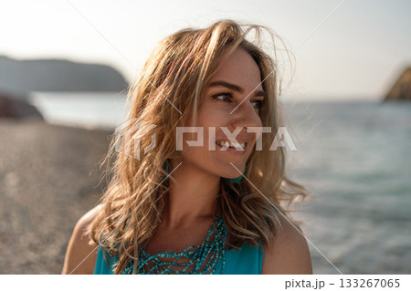 Woman beach smile. Happy young woman looking away with a joyful expression on a sunny beach. Summer vacation portrait. 133267065