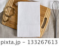 Mock-up of a white kitchen waffle towel on a wooden cutting board with steel cookie cutters and a 133267613