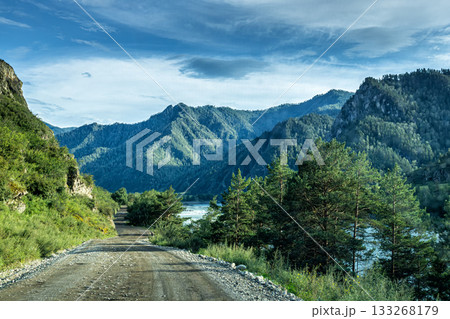A picturesque dirt road along a mountain river 133268179