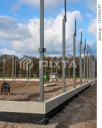 Steel structural columns installed on concrete foundation at early-stage construction site Steel structural columns installed on concrete foundation at early-stage construction site 133268237