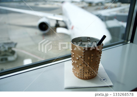 Frankfurt, Germany, June 10, 2019: Moscow Mule Cocktail with View of Long Haul Aircraft at the Gate Frankfurt, Germany, June 10, 2019: Moscow Mule Cocktail with View of Long Haul Aircraft at the Gate 133268578
