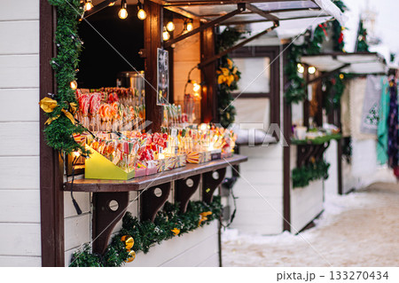 Christmas street market. Wooden houses for selling Christmas decorations and toys. Winter holiday season. 133270434
