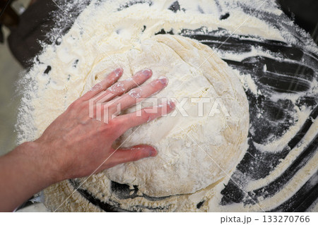 Making Fresh Yeast Dough by Hand with Flour on Kitchen Table, Close Up Process Making Fresh Yeast Dough by Hand with Flour on Kitchen Table, Close Up Process 133270766