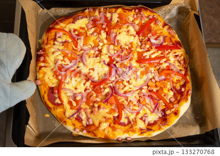 Ready Pizza with Cheese and Vegetables Taken Out of Oven in Mitt Ready Pizza with Cheese and Vegetables Taken Out of Oven in Mitt 133270768
