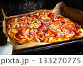 Homemade Pizza with Vegetables and Ham Baking in Oven on Parchment 133270775