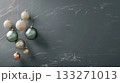 A wall with a grey background and a bunch of Christmas ornaments hanging from it. Poster, banner with copy space 133271013