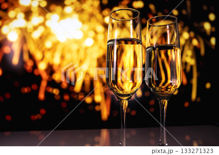 two sparkling champagne glasses captured just before fireworks illuminate night sky during festivities two sparkling champagne glasses captured just before fireworks illuminate night sky during festivities 133271323