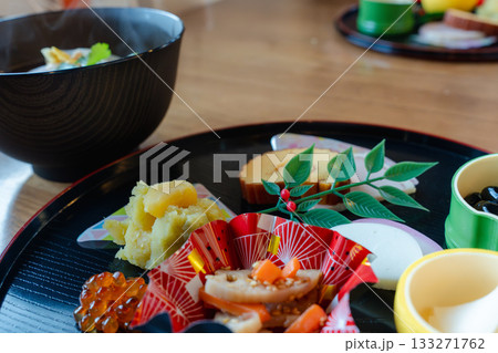お雑煮とおせち料理を半月盆に盛り付けた華やかな正月の食卓 お雑煮とおせち料理を半月盆に盛り付けた華やかな正月の食卓 133271762