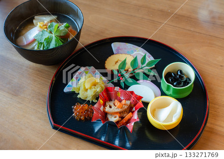 お雑煮とおせち料理を半月盆に盛り付けた華やかな正月の食卓 お雑煮とおせち料理を半月盆に盛り付けた華やかな正月の食卓 133271769