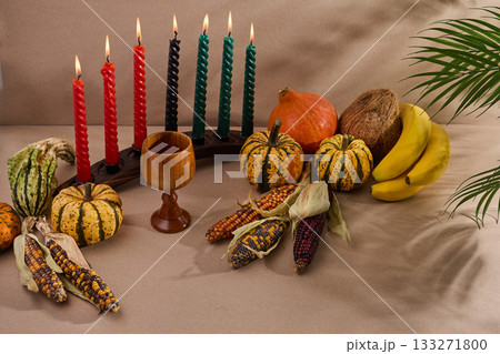 Festive Kwanzaa Setting. A warm Kwanzaa scene with a kinara, fruits, and vegetables 133271800