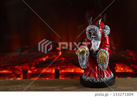 Dark Santa by Fireplace. Dark Santa figure with horns stands before glowing fireplace 133271804