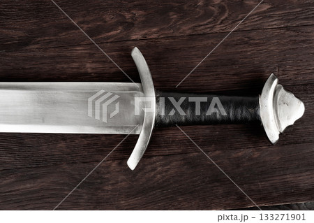 Viking sword on wooden table. 133271901