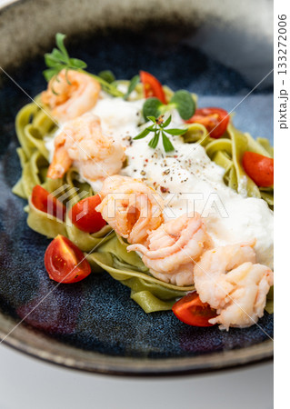 Gourmet spinach tagliatelle with shrimp, burrata and cherry tomatoes in ceramic bowl Gourmet spinach tagliatelle with shrimp, burrata and cherry tomatoes in ceramic bowl 133272006