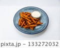 Crispy sweet potato fries with creamy dip on a blue ceramic plate, overhead food photo 133272032