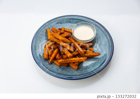 Crispy sweet potato fries with creamy dip on a blue ceramic plate, overhead food photo 133272032