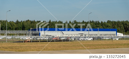 Aerial view of a vast parking lot filled with newly manufactured cars Aerial view of a vast parking lot filled with newly manufactured cars 133272045