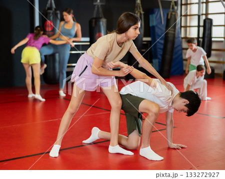 Teenage boy and girl practice self-defense in pairs 133272927