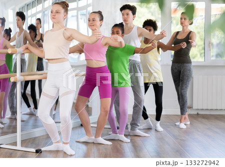 Woman teacher corrects teenagers in plie movement Woman teacher corrects teenagers in plie movement 133272942